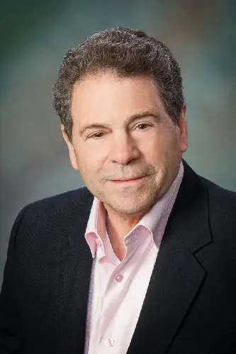 A man in a suit and pink shirt.