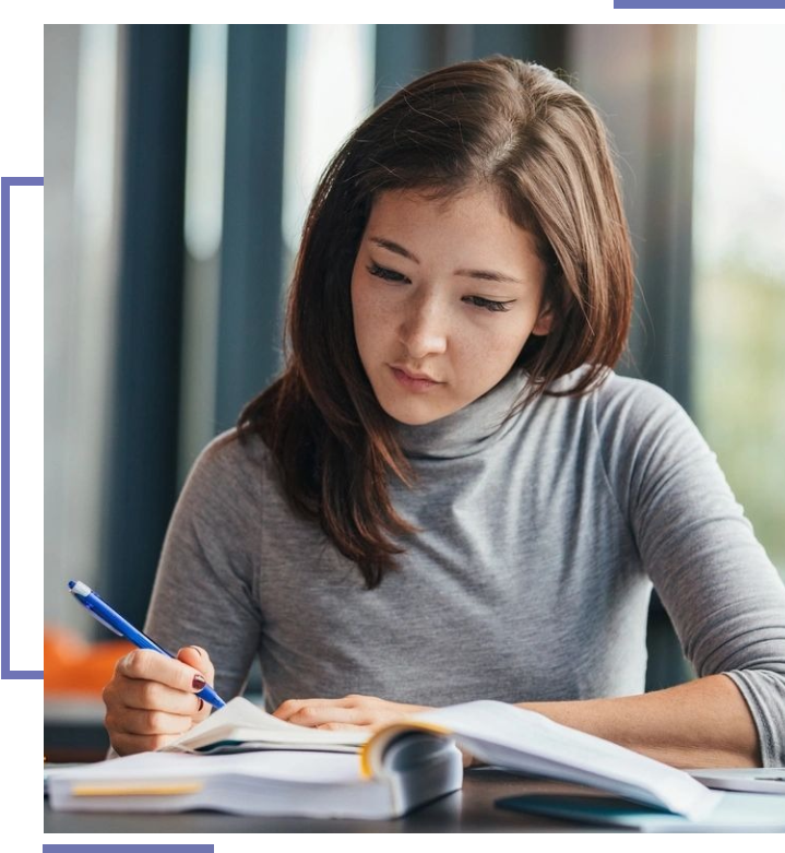 A woman is writing on paper at the table